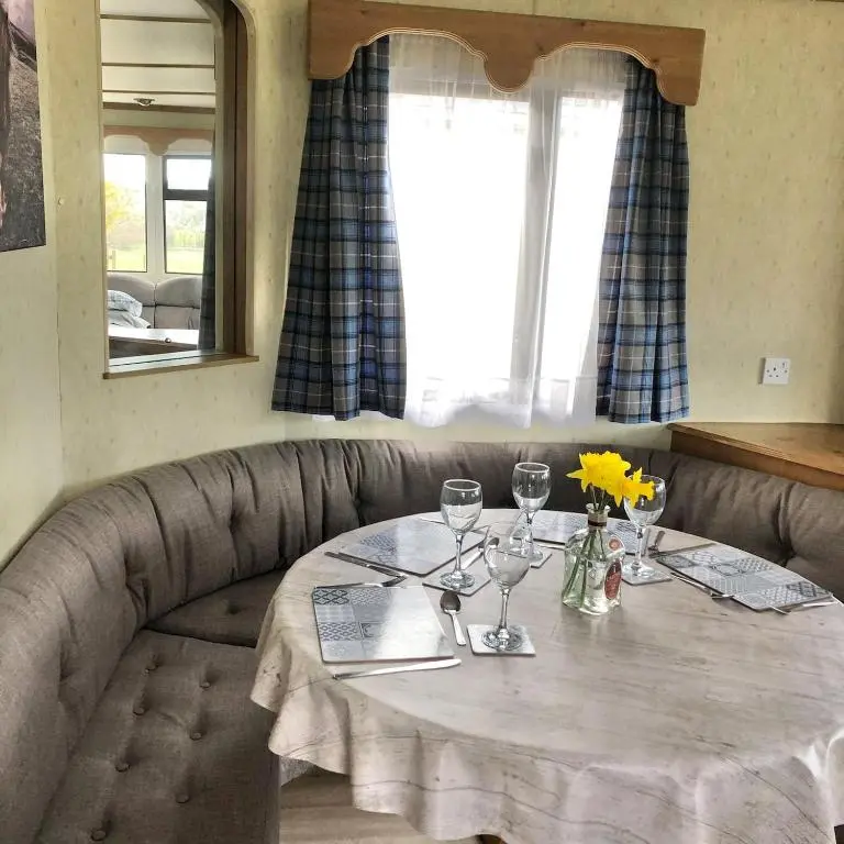 a table with wine glasses and flowers on it at Lettoch Farm Holiday Home in Dufftown