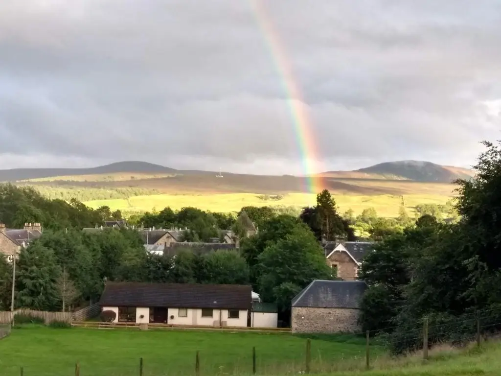a rainbow over a small town with a house at Ardvonie House in Kingussie