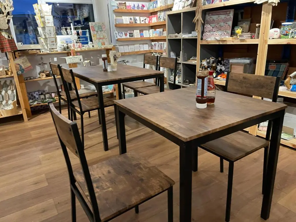 two tables and chairs in a store with bottles on them at Coorie Doon Cabin! Great Scottish Welcome in Fort Augustus