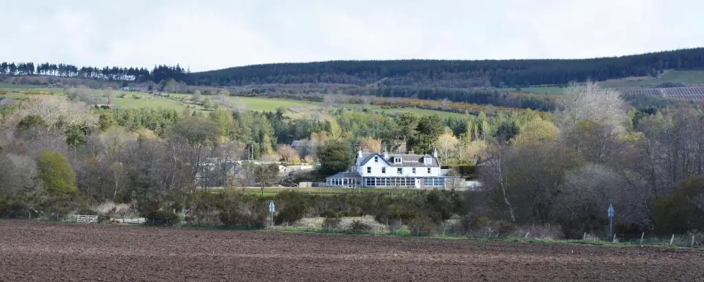 a large house sitting on top of a hill at Feughside in Strachan