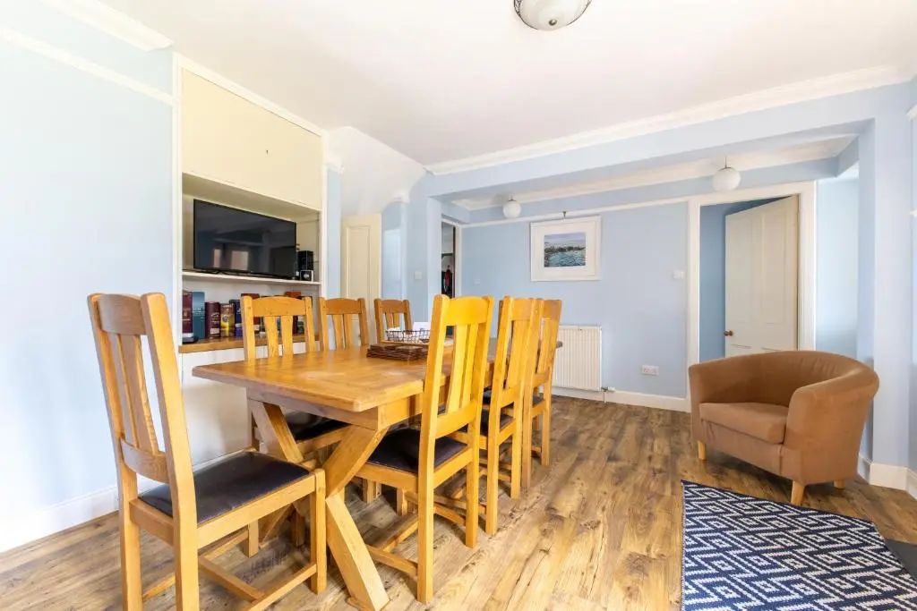 a kitchen and dining room with a wooden table and chairs at Seaview House - A Traditional Home by the Beach in Nairn