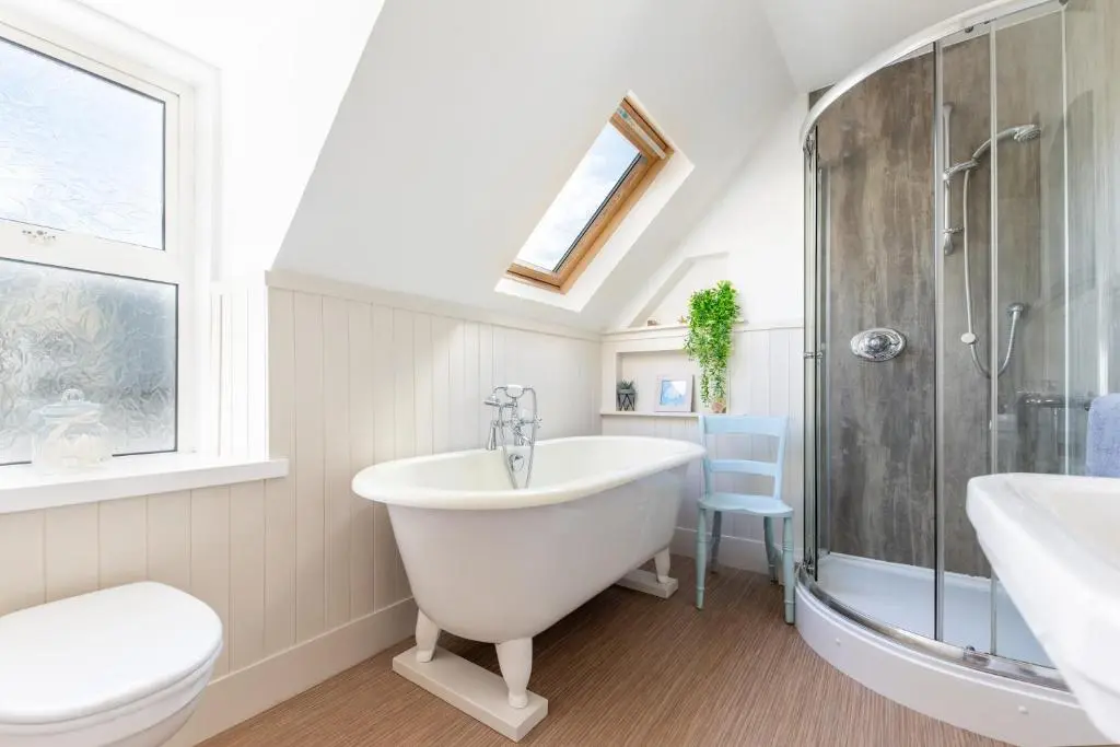a bathroom with a tub and a shower and a toilet at Seaview House - A Traditional Home by the Beach in Nairn