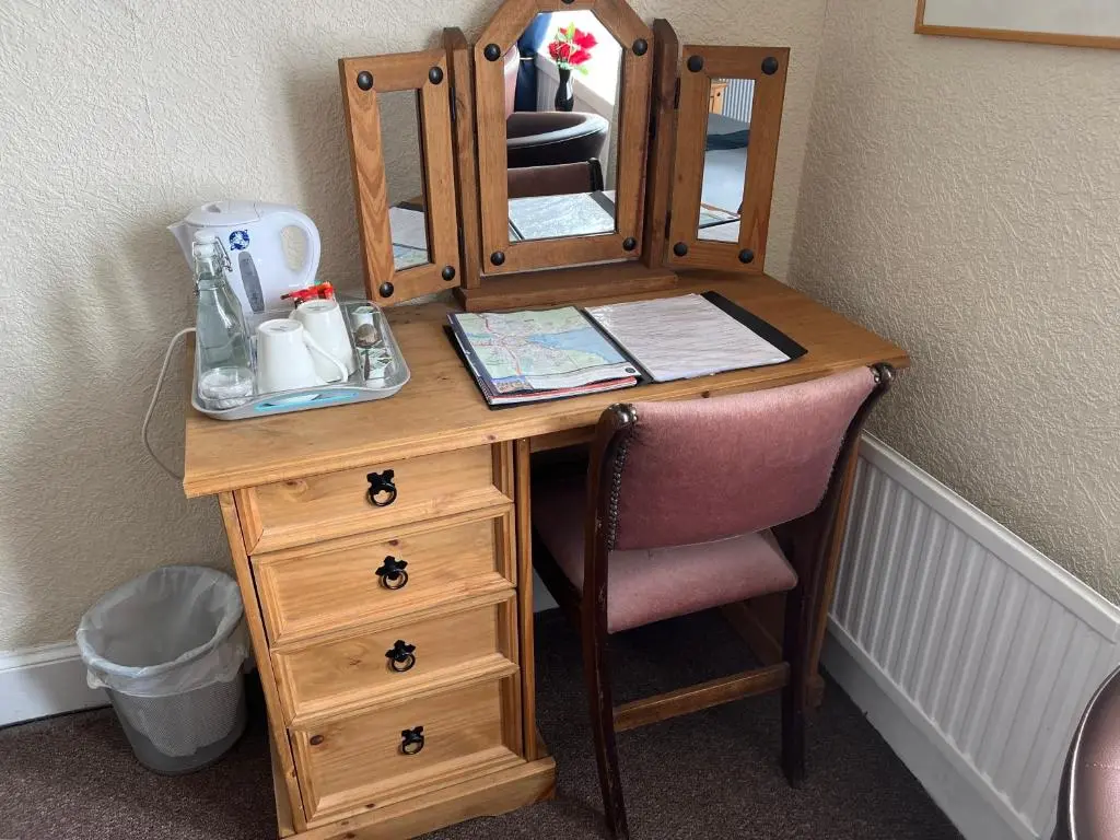 a wooden desk with a mirror and a pink chair at Harbour bridge, Camps bar in Wick