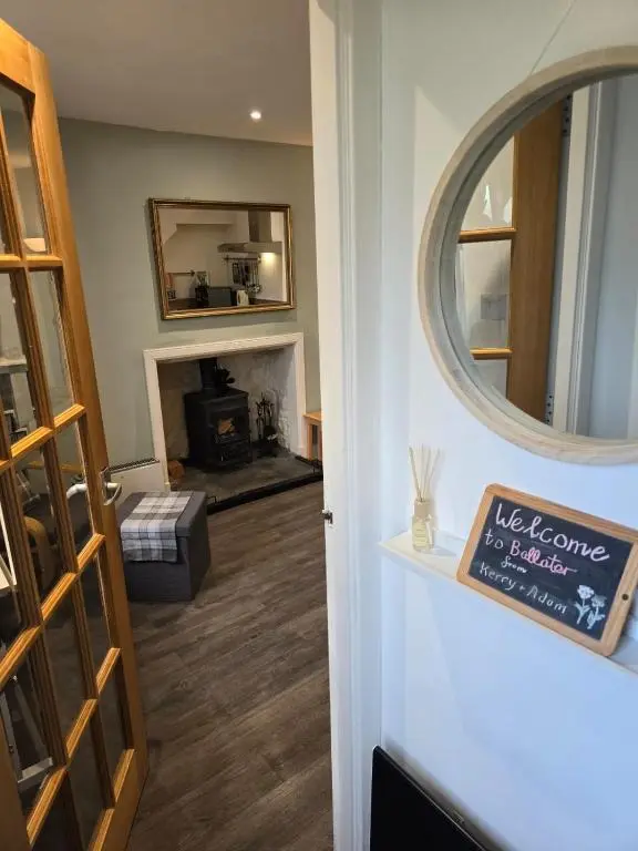 a living room with a fireplace and a mirror at Pannanich View Cottage, Ballater in Ballater