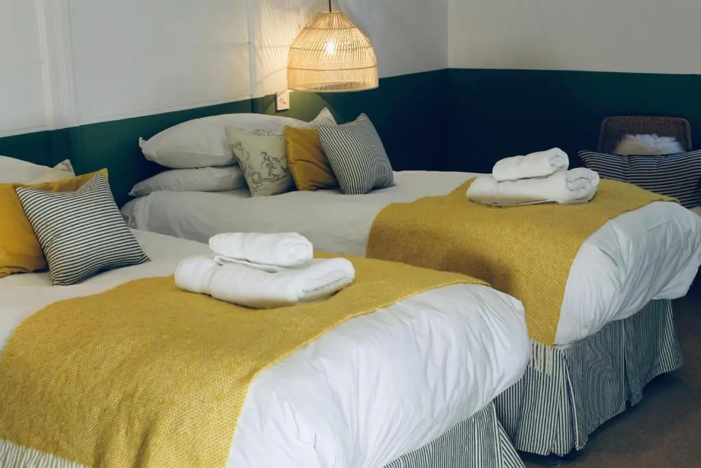two beds with towels on top of them in a room at The Boat Inn in Aboyne