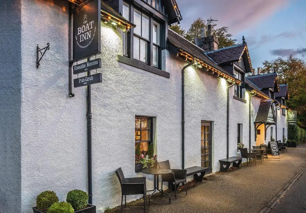 a white building with a sign on the side of it at The Boat Inn in Aboyne