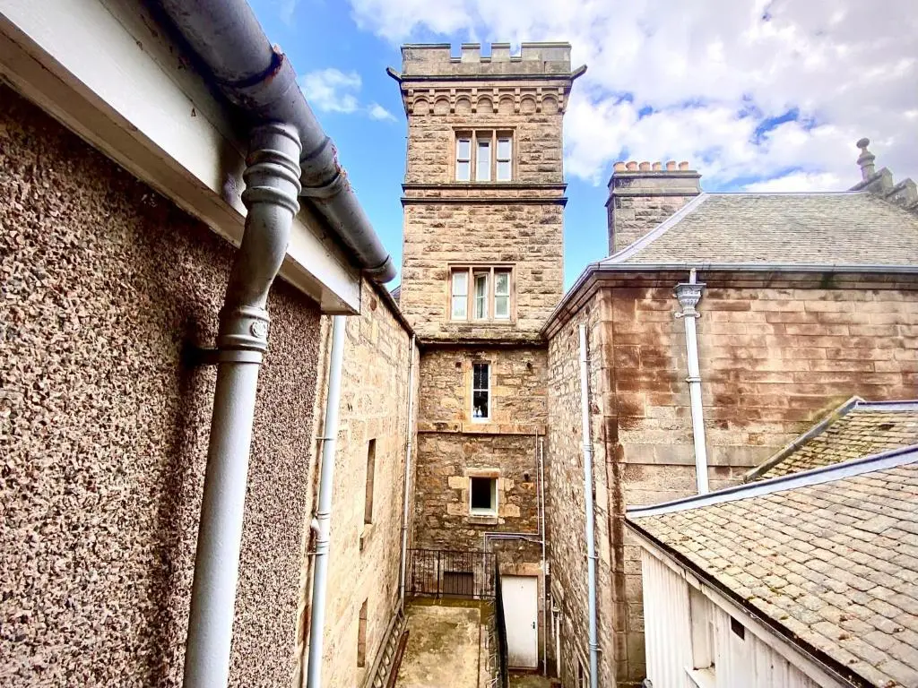 a view of an old castle with two towers at Grampian Serviced Apartments - Treetops Apartments in Elgin