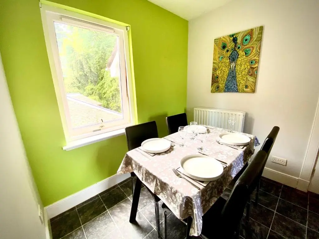 a dining room with a table and a window at Grampian Serviced Apartments - Treetops Apartments in Elgin