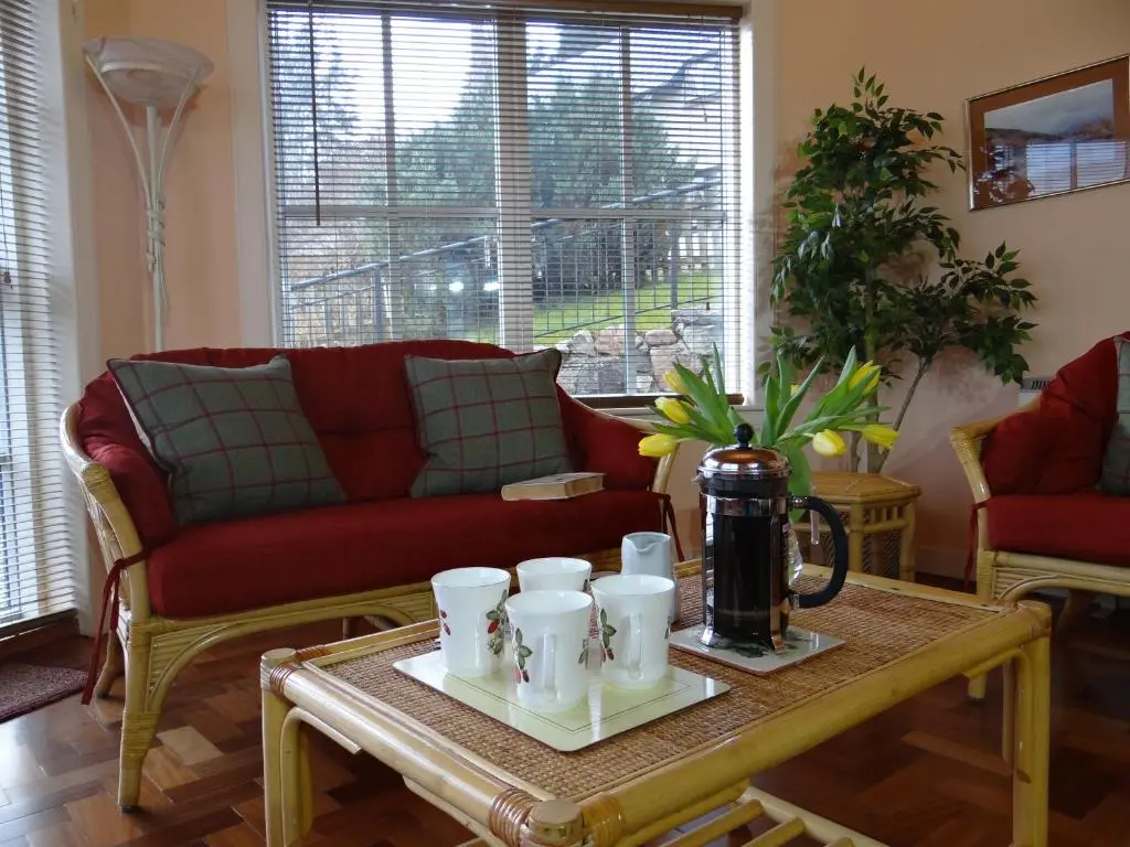a living room with a coffee table with cups on it at The Cottage Bogroy in Carrbridge