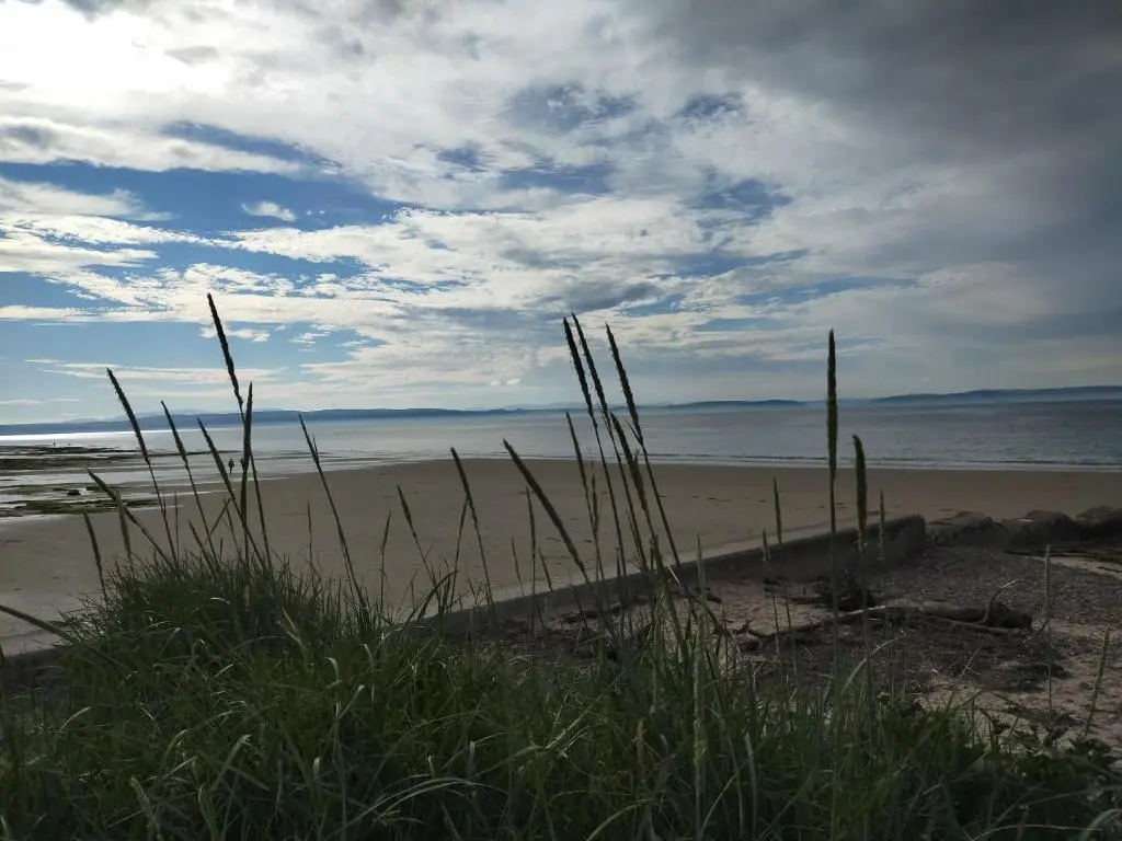 a sandy beach with a view of the ocean at Shadow's Cottage situated in Fishertown, Nairn. in Nairn