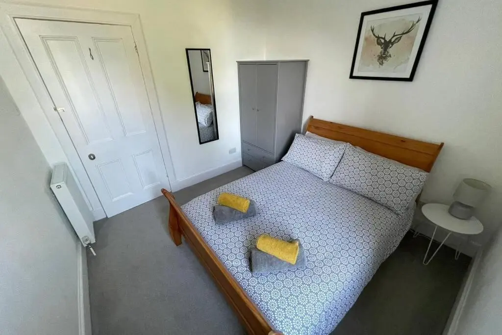 a bedroom with a bed with two yellow pillows at No 10 Immaculate City Centre, Top Floor 2 Bed Flat with Free Parking in Inverness