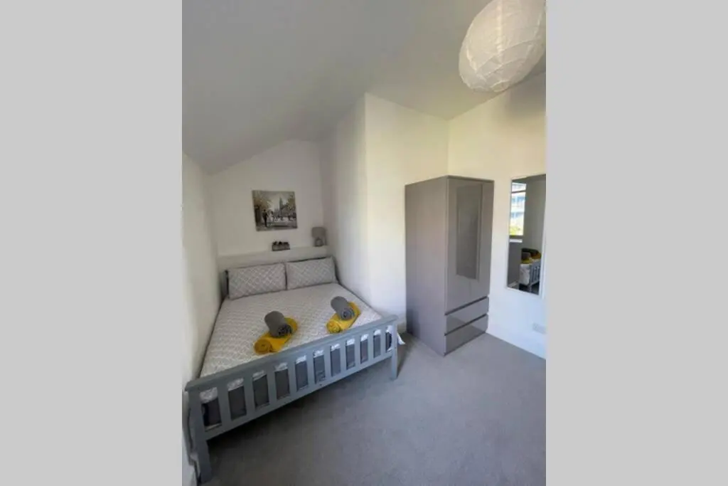 a bedroom with a bed with yellow pillows on it at No 10 Immaculate City Centre, Top Floor 2 Bed Flat with Free Parking in Inverness