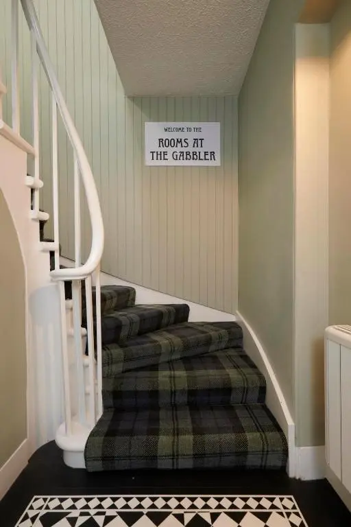 a room with stairs with a sign that reads hooks at the quarterback at Downright Gabbler in Beauly