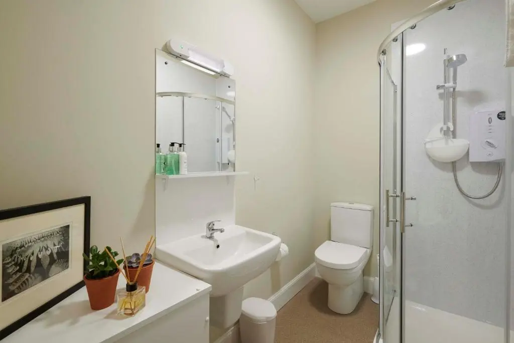 a white bathroom with a toilet and a sink at Downright Gabbler in Beauly