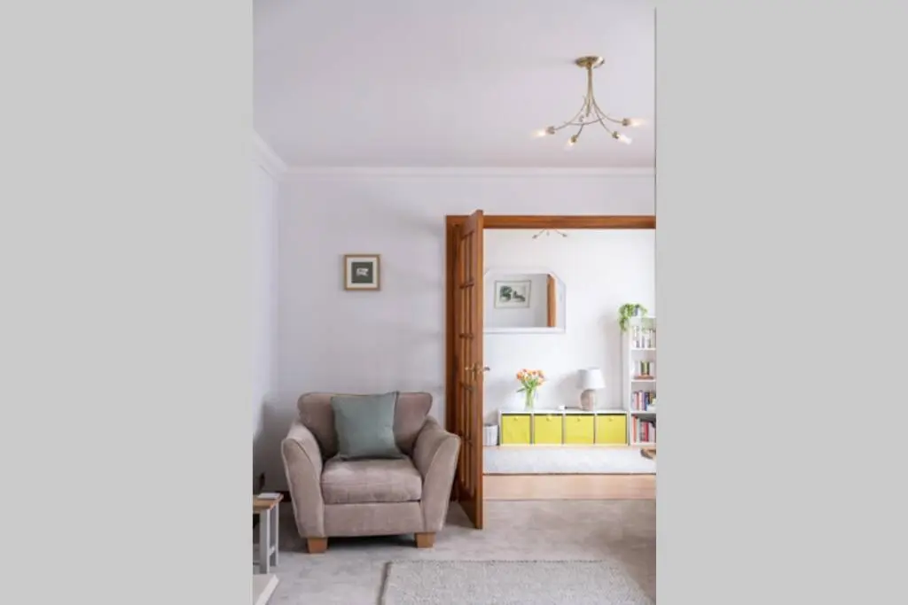 a living room with a chair and a hallway at Bowmore in Lossiemouth