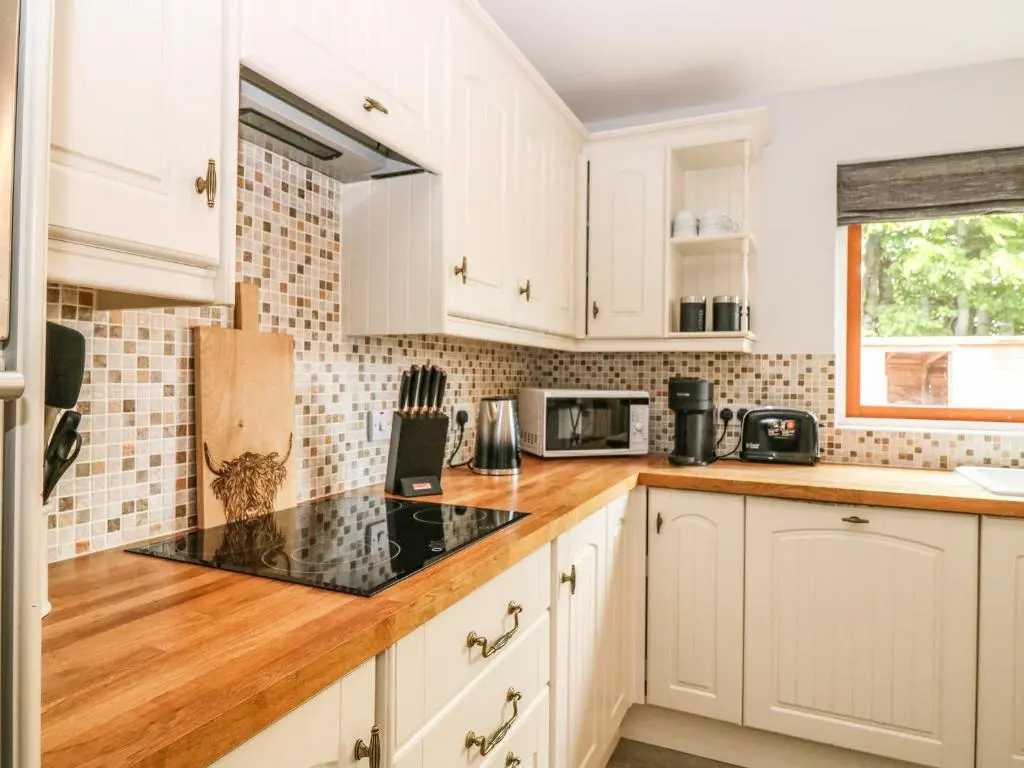 a kitchen with white cabinets and a counter top at Tombeck in Tomintoul