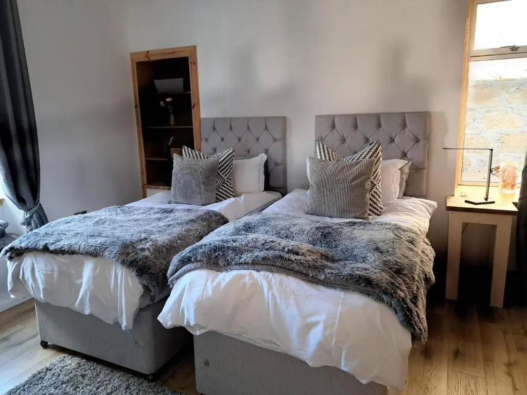 a bedroom with two beds and a window at The Apartment in Aberlour in Aberlour