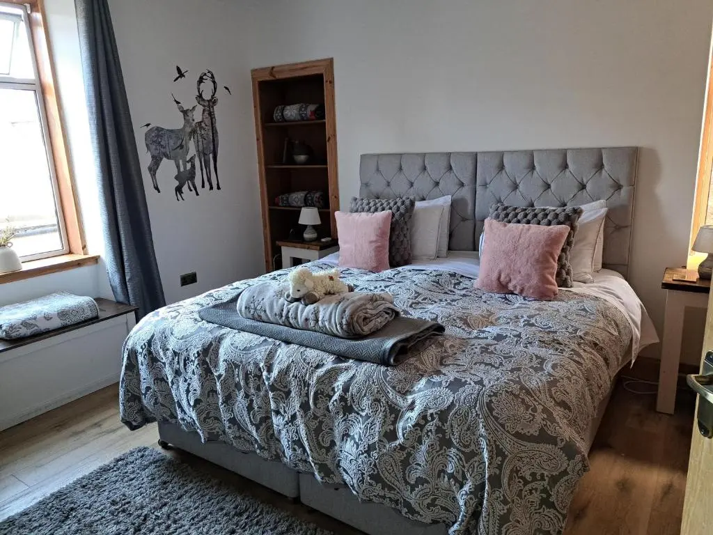 a bedroom with a bed with a dog laying on it at The Apartment in Aberlour in Aberlour