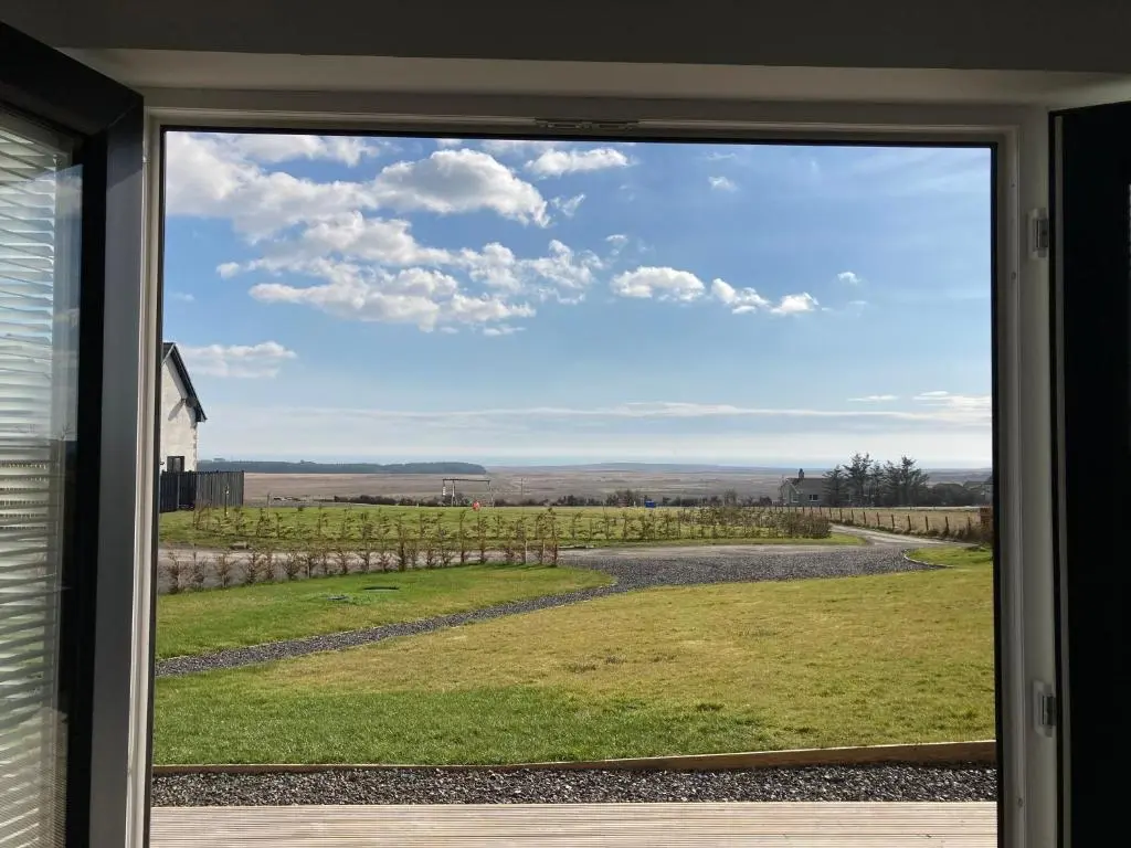 a window view of a field from a house at North Coast Escapes in Thrumster