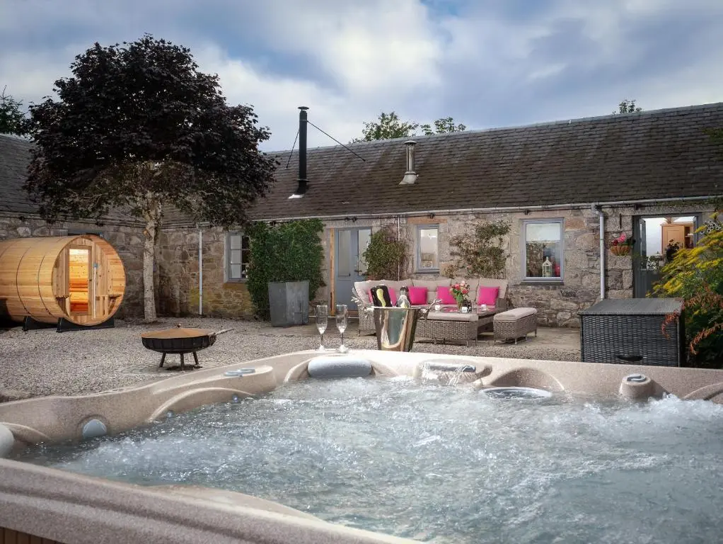 a hot tub in the yard of a house at The Eagle's Nest - large house with hot tub and sauna in Boat of Garten
