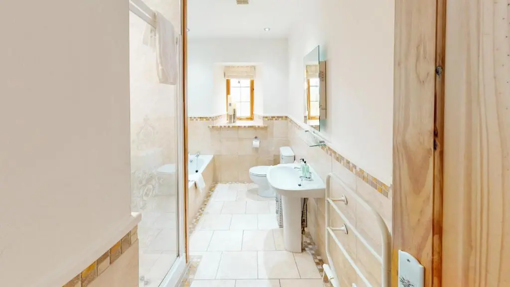 a bathroom with a sink and a toilet and a mirror at The Eagle's Nest - large house with hot tub and sauna in Boat of Garten