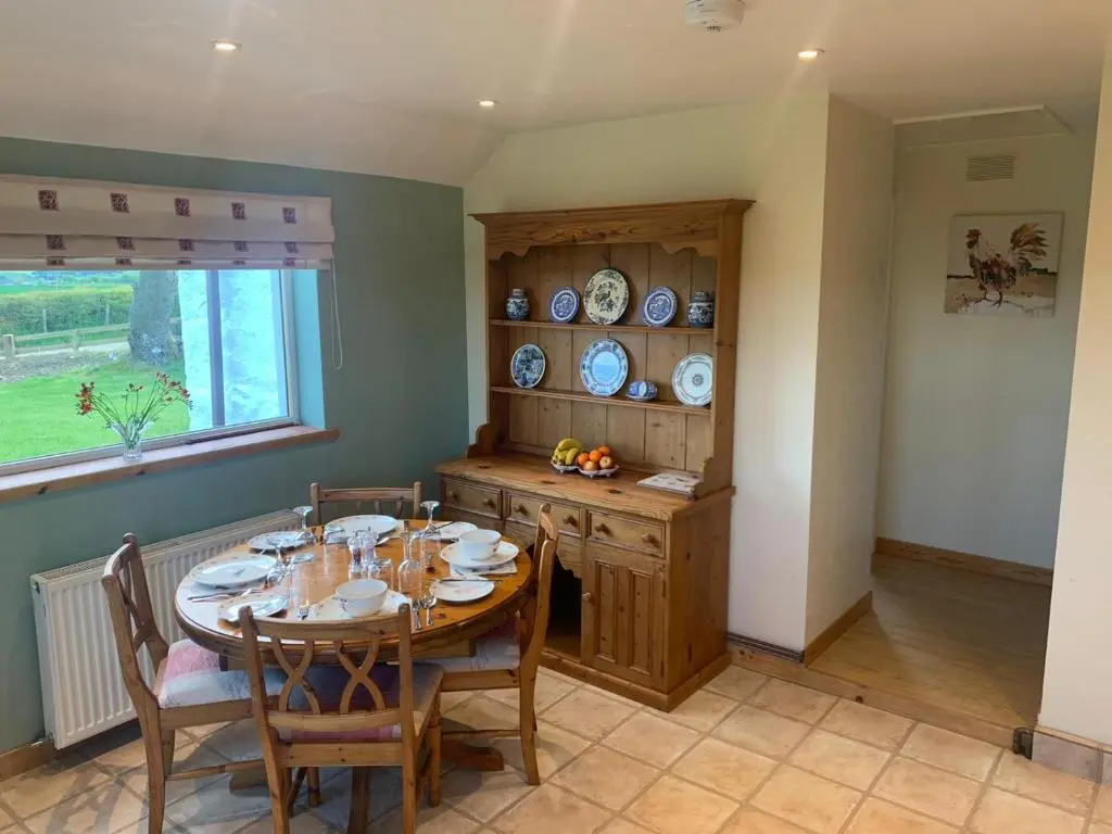 a dining room with a table and chairs and a window at Meikle Aucheoch Holiday Cottage, plus Hot Tub, Near Maud, in the heart of Aberdeenshire in Peterhead