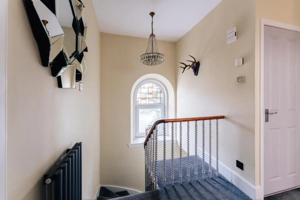 a room with a staircase with a spider decoration on the wall at Luxury Inverness central apartment private parking in Inverness