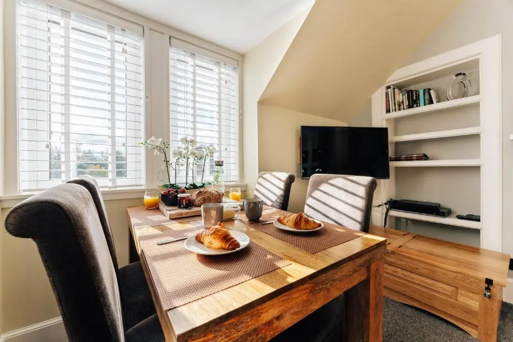 a dining room with a table with food on it at Luxury Inverness central apartment private parking in Inverness