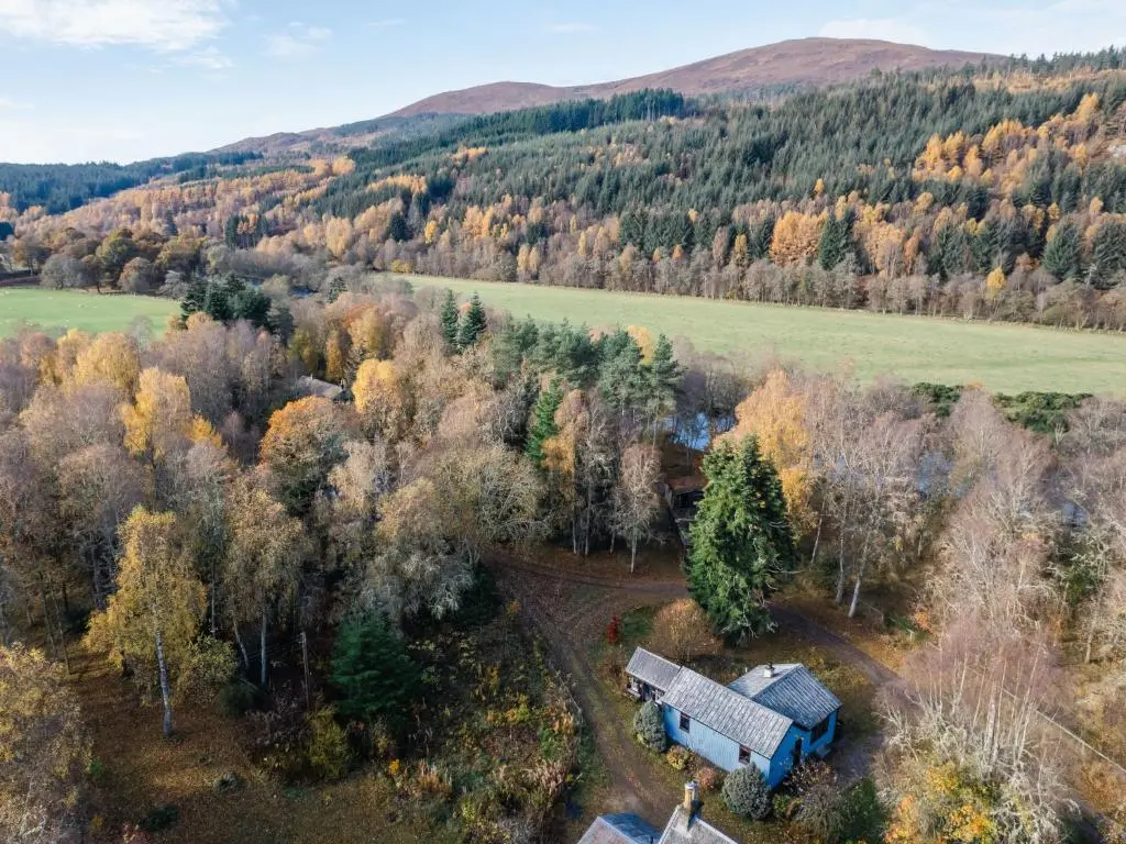 an aerial view of a blue barn in the forest at Holiday Home Fishermans by Interhome in Inverness