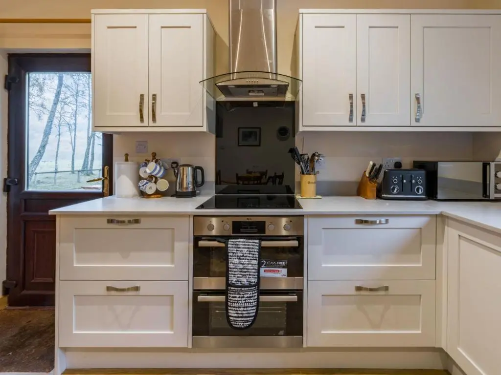 a kitchen with white cabinets and a stove top oven at Holiday Home Fishermans by Interhome in Inverness