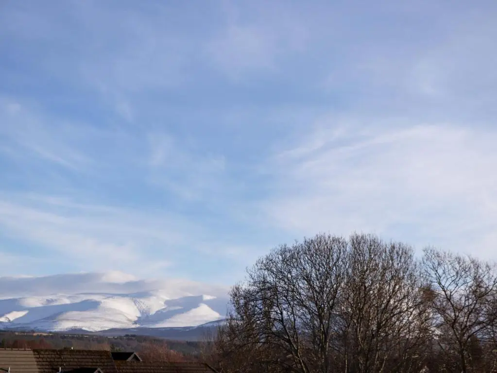 a group of snow covered mountains in the distance at 3 Croftside in Aviemore