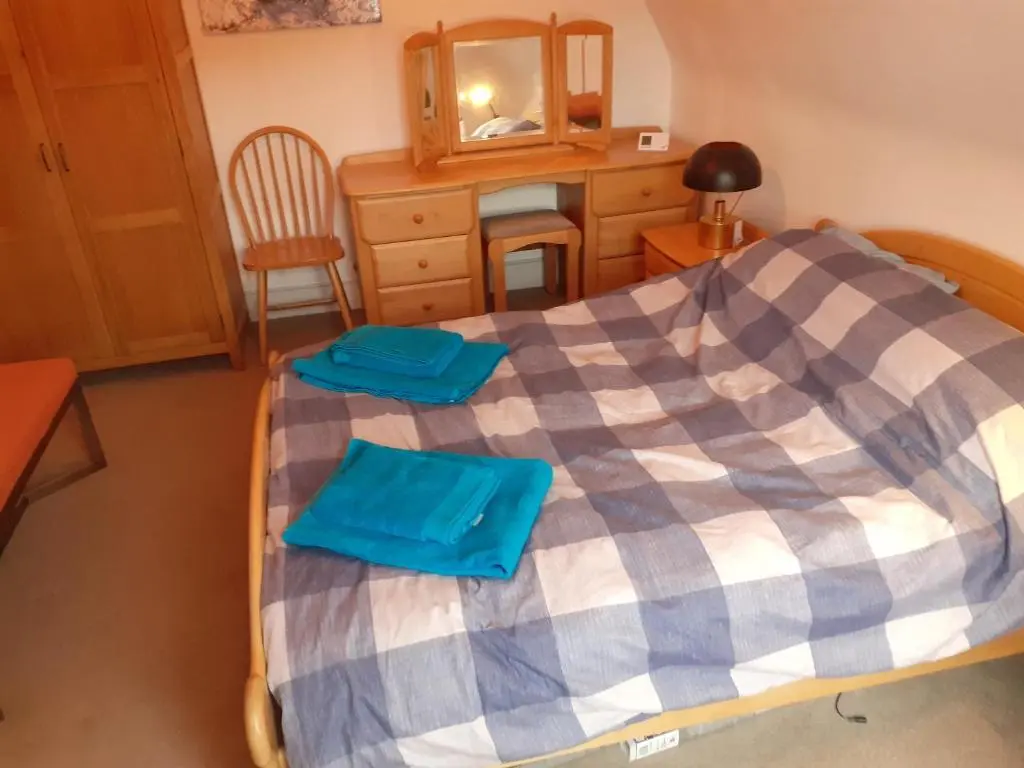 a bedroom with a bed and a dresser and a mirror at Just off the Square... Ballater in Ballater