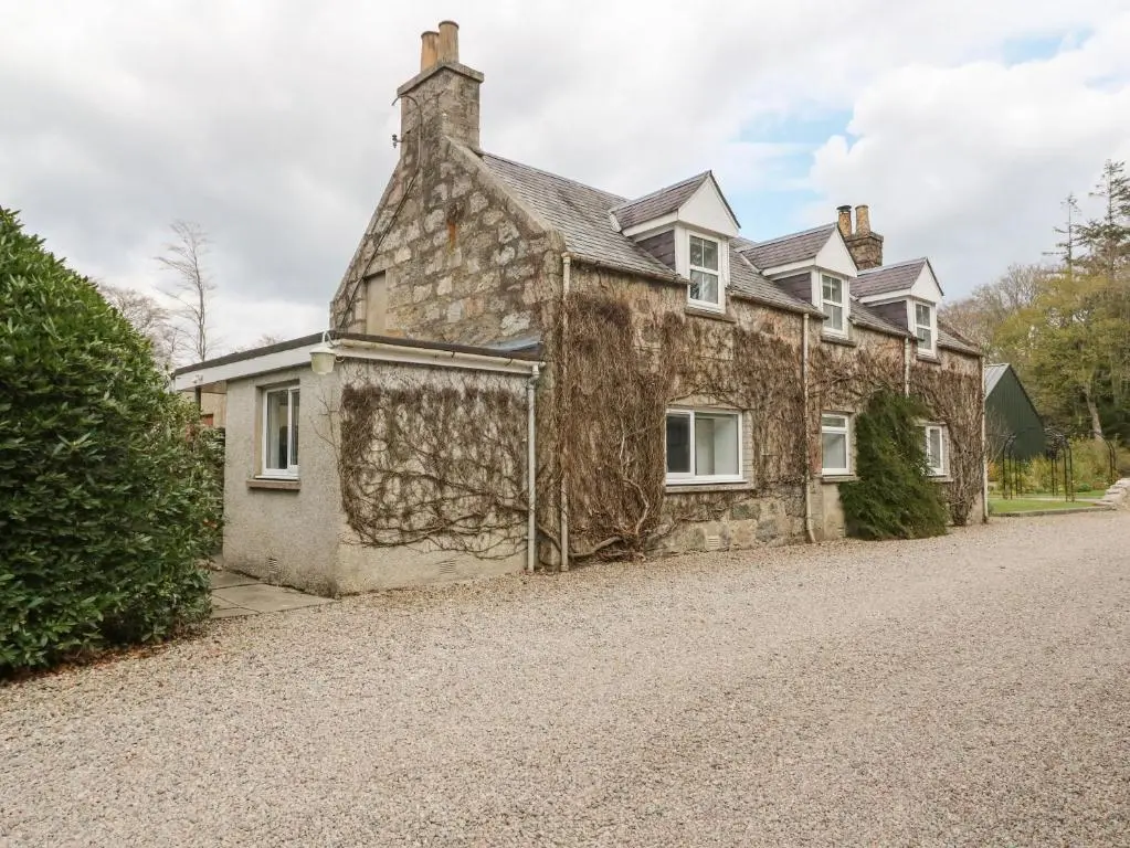 an old stone house on the side of a road at Storkery Cottage in Aberdeen