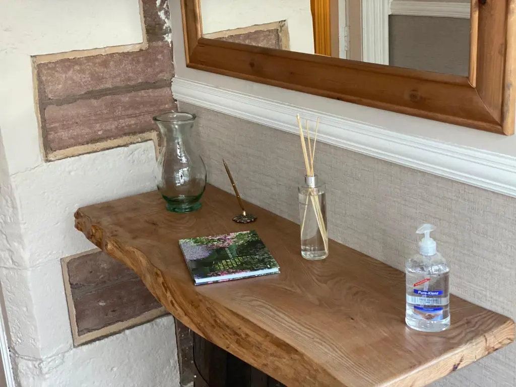 a wooden table with two vases and a mirror at Adrian's Guest House in Inverness
