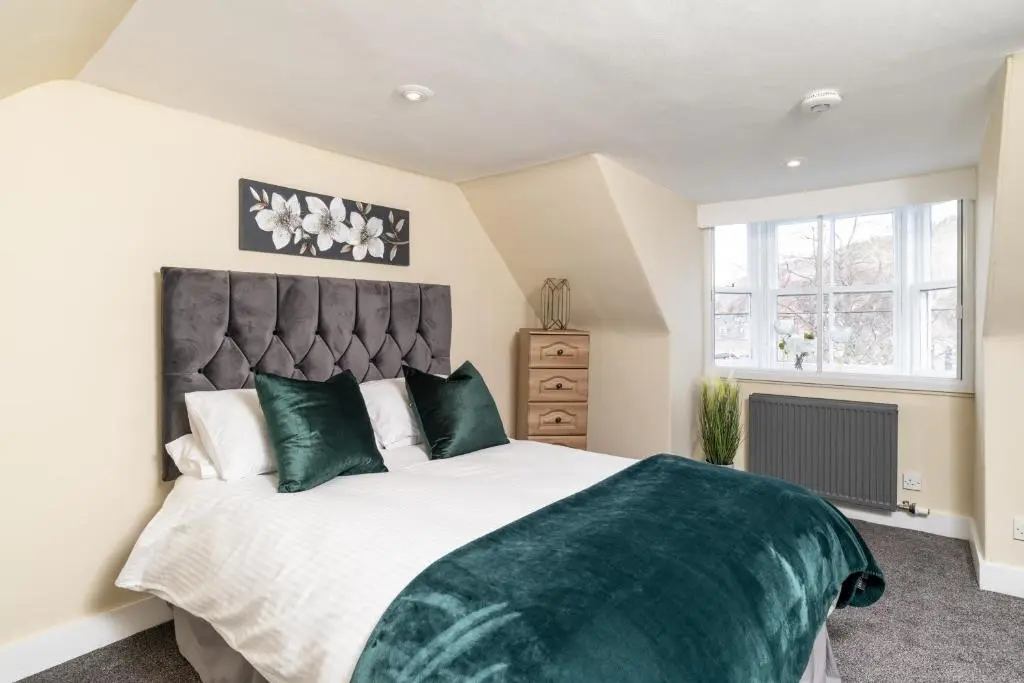a bedroom with a large bed and a window at The Green Inn Rooms in Ballater