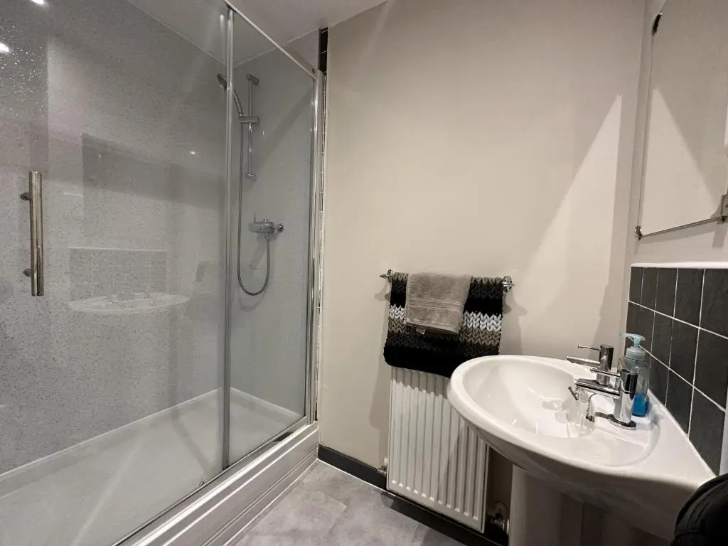 a bathroom with a shower and a sink at Waterside View Apartment in Inverness