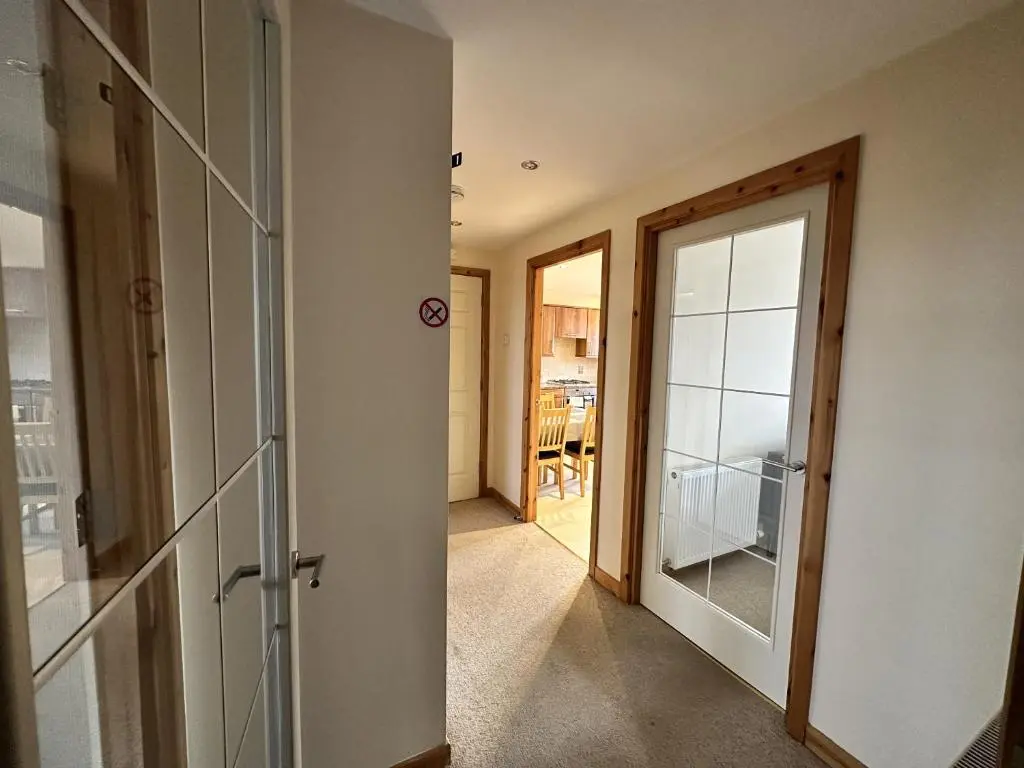 a hallway with a door leading into a room at Waterside View Apartment in Inverness