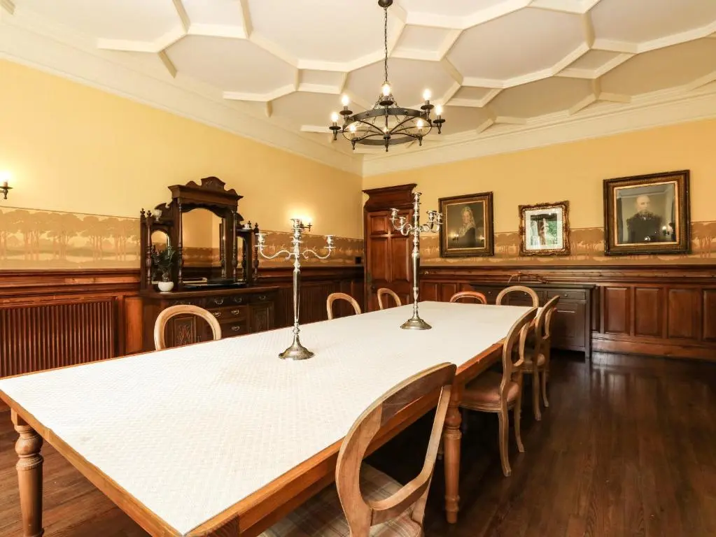 a dining room with a white table and chairs at Bearnock Lodge in Inverness