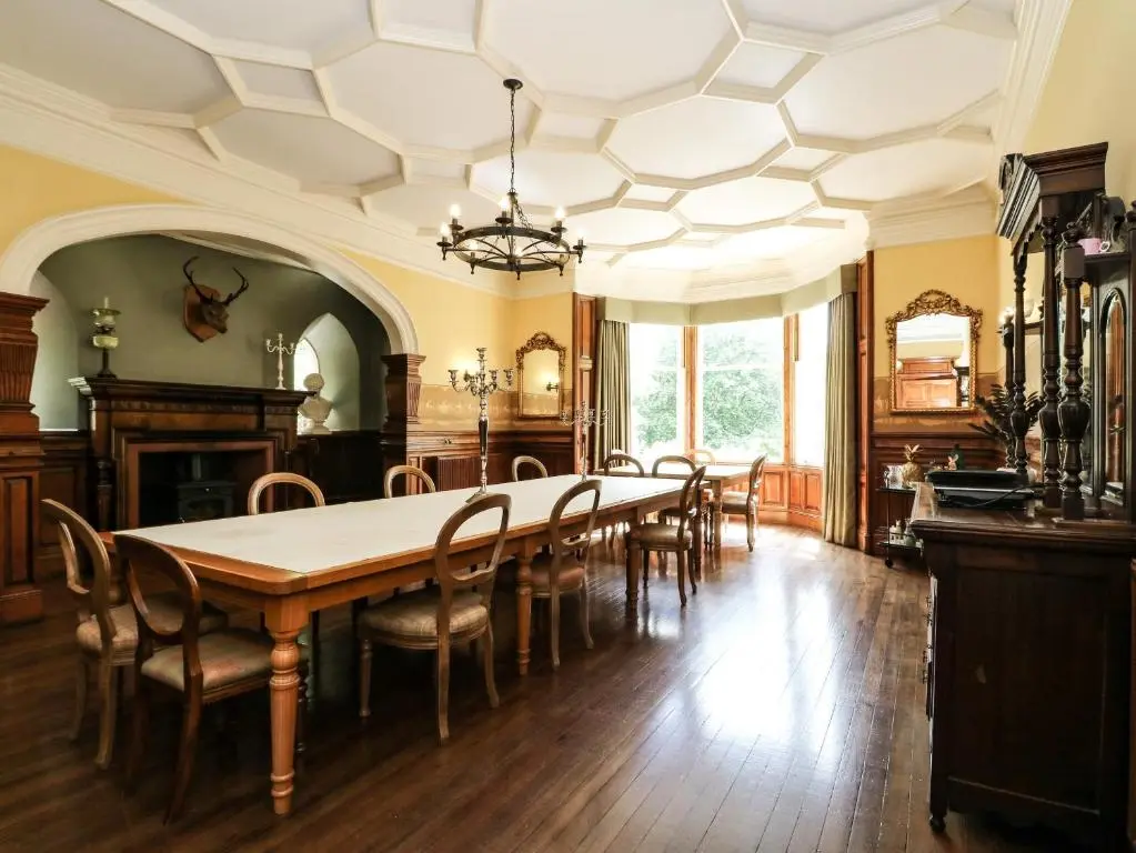 a dining room with a large table and chairs at Bearnock Lodge in Inverness