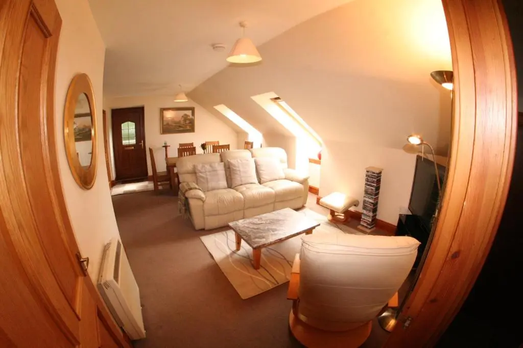 a living room with a couch and a table at Macallen in Nairn