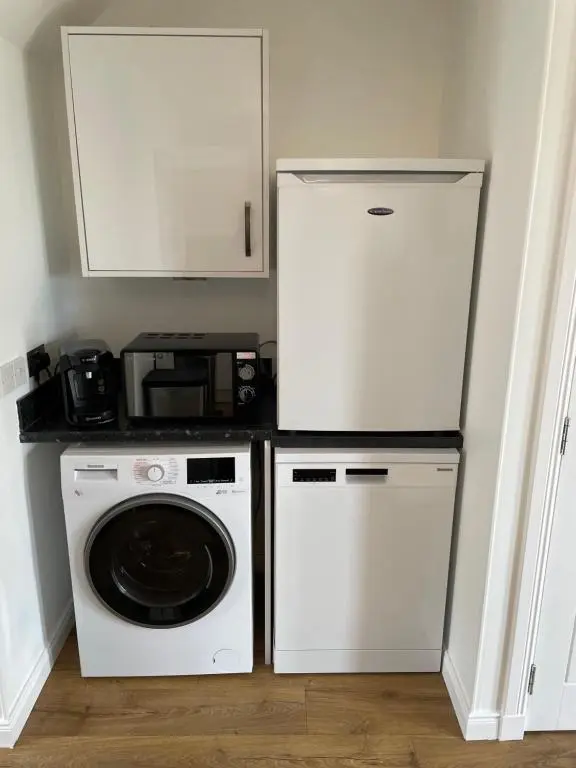 a kitchen with a refrigerator and a washing machine at Gorsebank Mews in Inverness