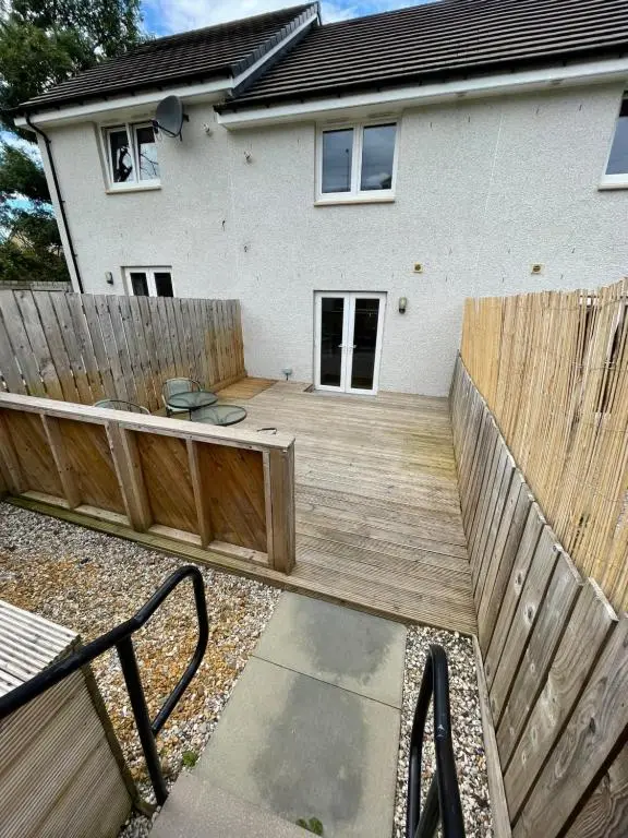 a wooden deck in front of a house at Gorsebank Mews in Inverness