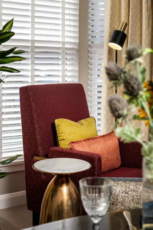 a living room with a red chair and a table at Relax in Super Size Copper Tub - 2 bedroom villa in Inverness