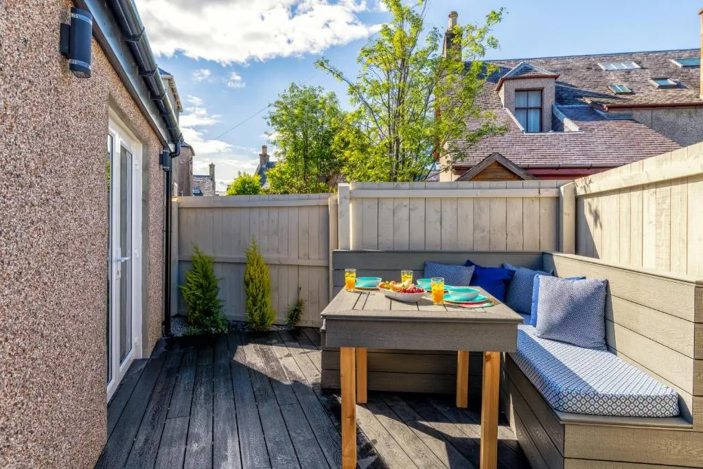 a small patio with a table and a bench at Relax in Super Size Copper Tub - 2 bedroom villa in Inverness