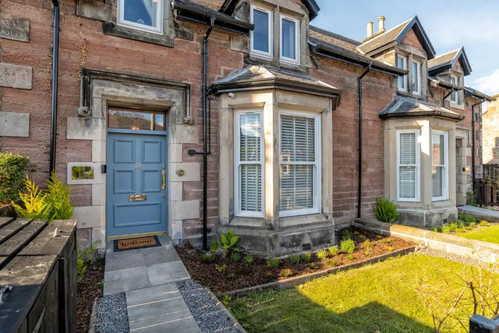 a brick house with a blue door at Relax in Super Size Copper Tub - 2 bedroom villa in Inverness