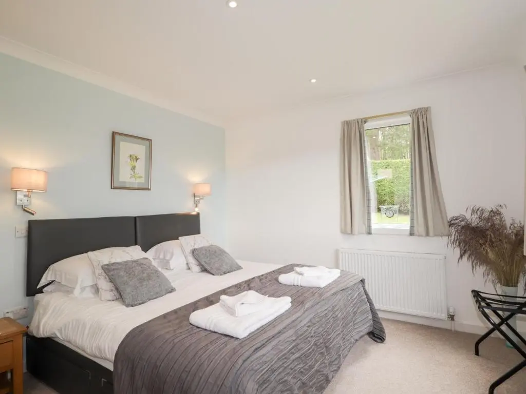 a bedroom with a large bed with towels on it at Culreach Lodge in Grantown on Spey