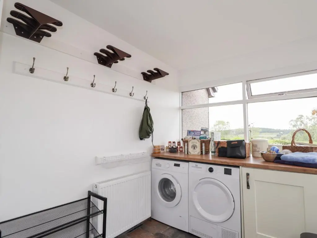 a white laundry room with a washer and dryer at Culreach Lodge in Grantown on Spey