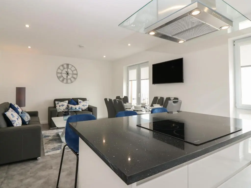 a kitchen and living room with a black counter top at Ocean View in Banff
