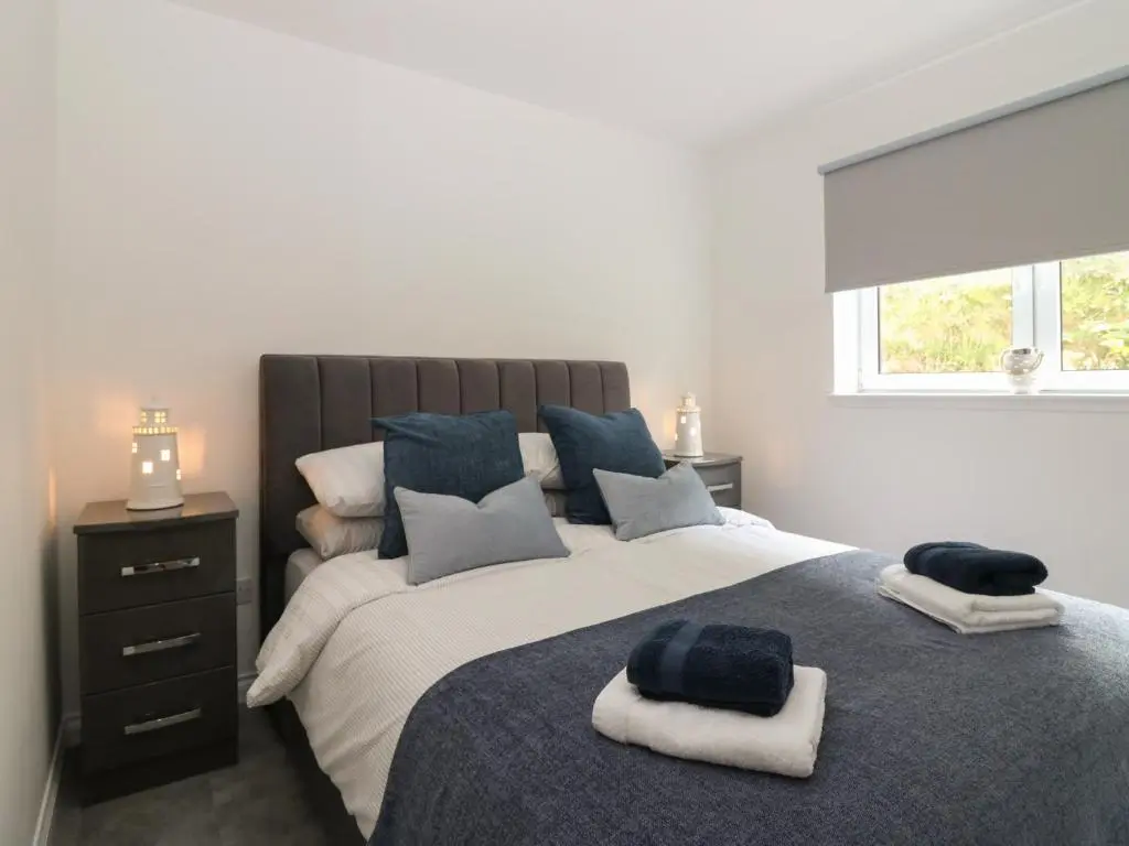 a bedroom with a large bed with towels on it at Ocean View in Banff
