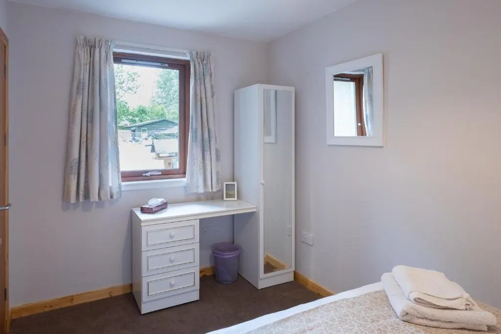 a bedroom with a white desk and a window at Contemporary One Bedroom Apartment Close To All Amenities In Conservation Area in Tain